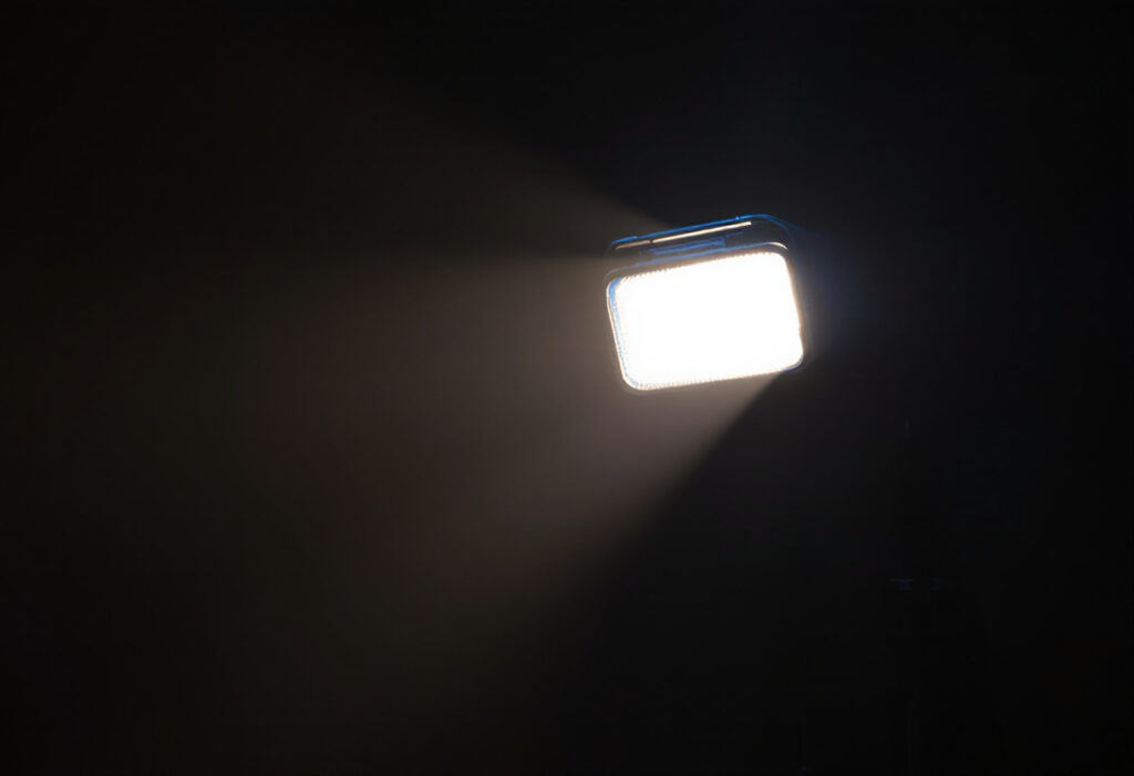 Flash emettant un faisceau de lumiere dans un studio sombre, lumiere bleue